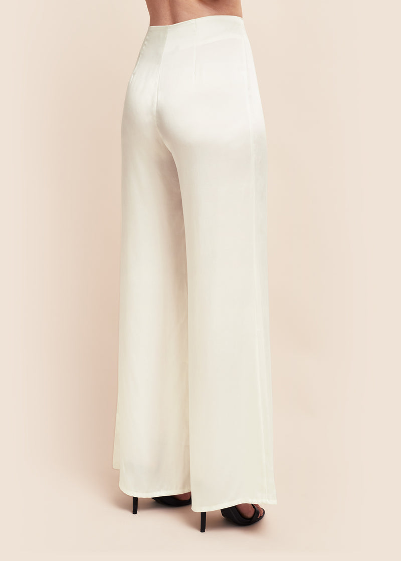 Rear side view of model wearing off-white silk satin wide leg flare trouser 